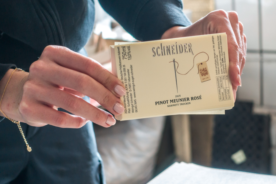 Eine Person hält Weinetiketten in der Hand