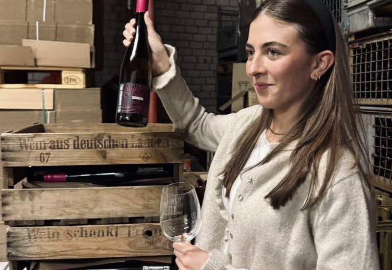 Anna-Lena Dentzer mit einer Weinflaschen und einem Weinglas