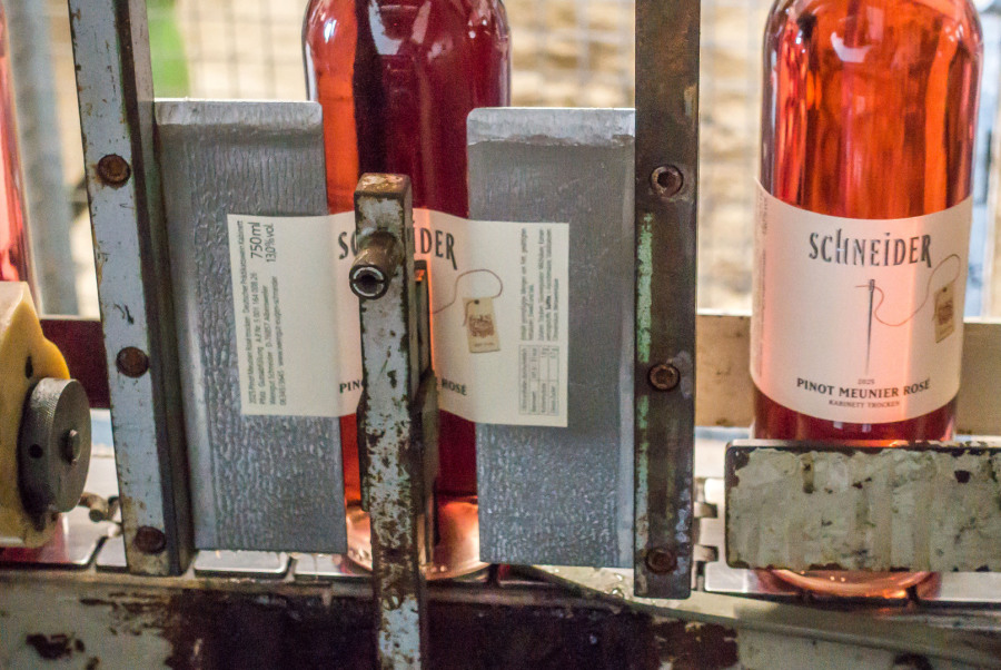 Ein Etikett wird auf die Flasche geklebt