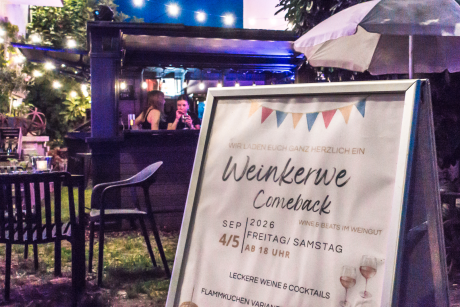 Großes Veranstaltungsschild mit der Bar im Hintergrund