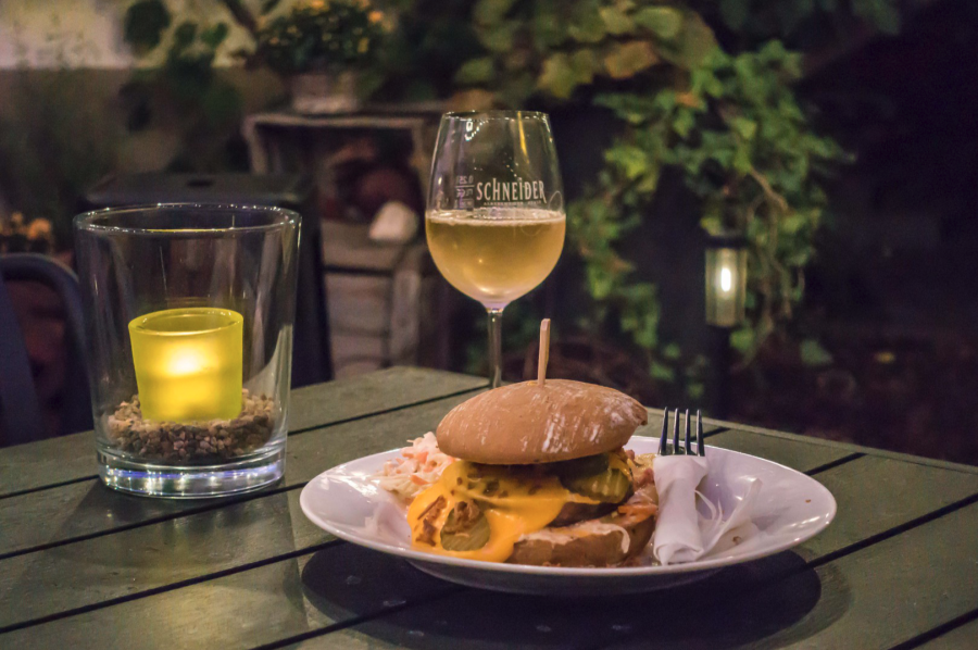 Saumagenburger mit Weinglas und Kerze